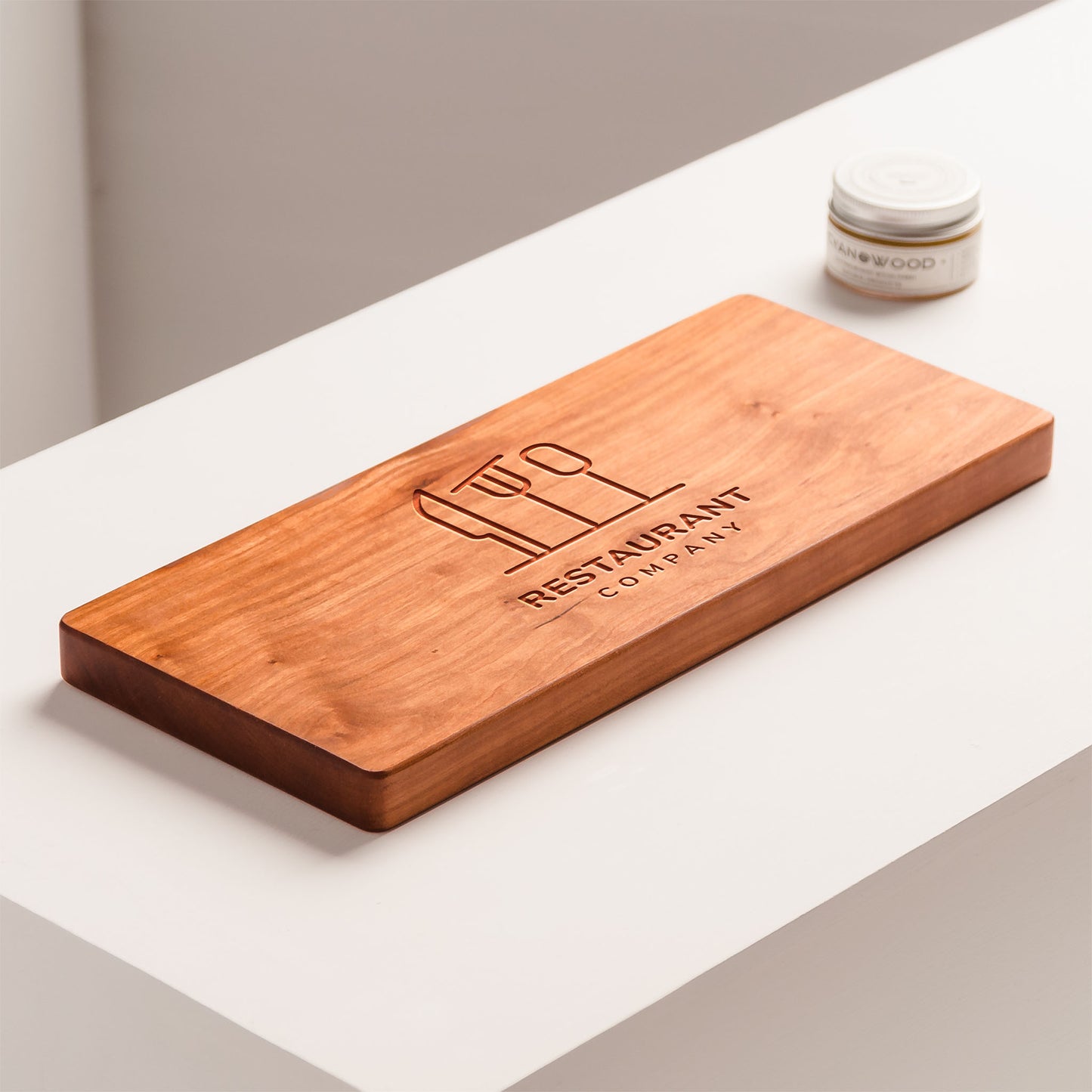 Wooden cutting board with engraved text on a white surface