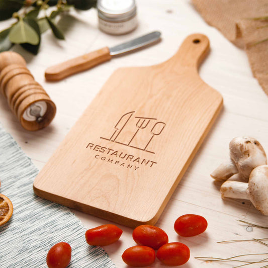 Personalized beech wood charcuterie board with engraved restaurant logo and handle.