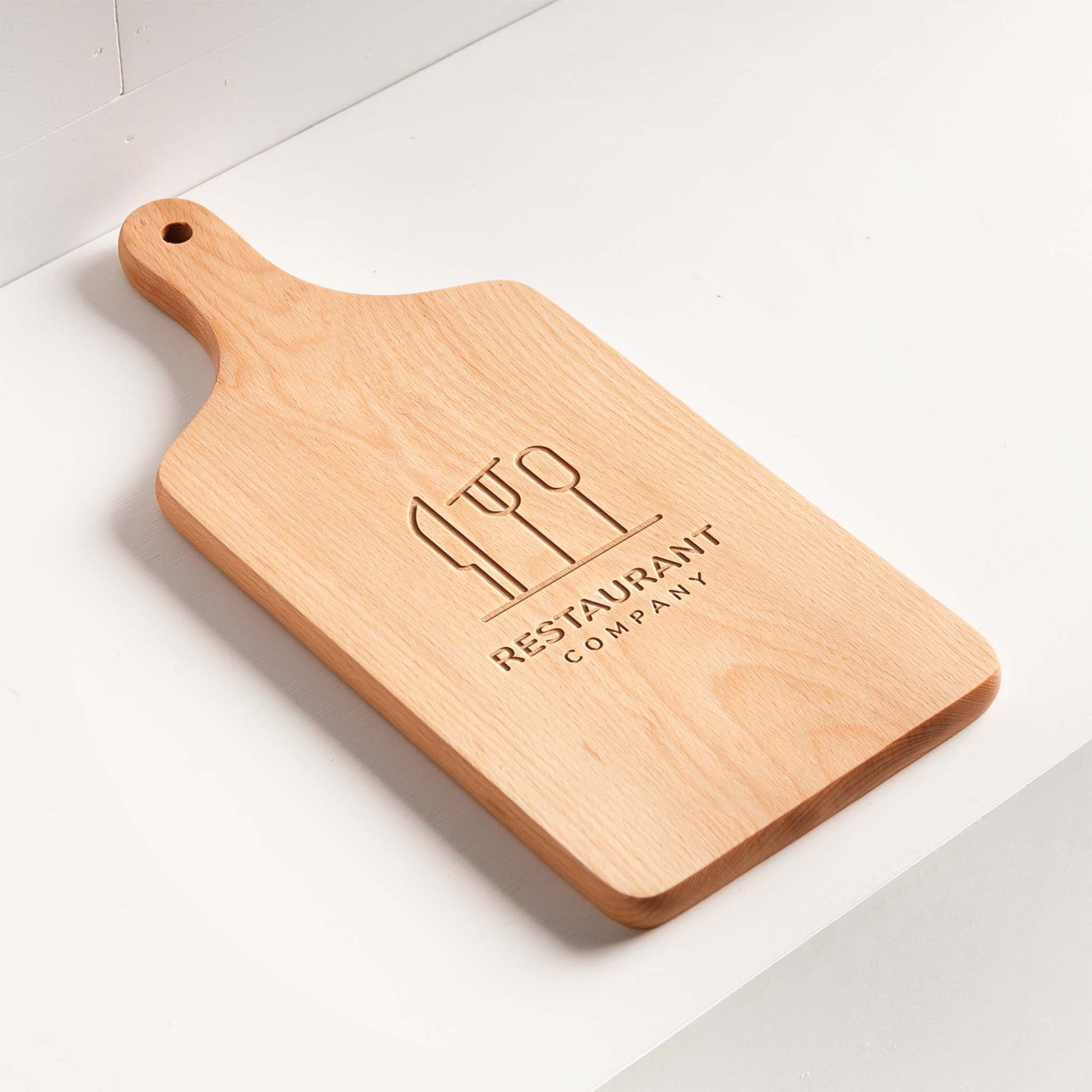 Custom restaurant logo serving board - beech wood close-up engraving.