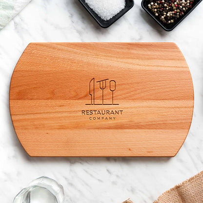 Wooden cutting board with engraved logo and text on a marble surface