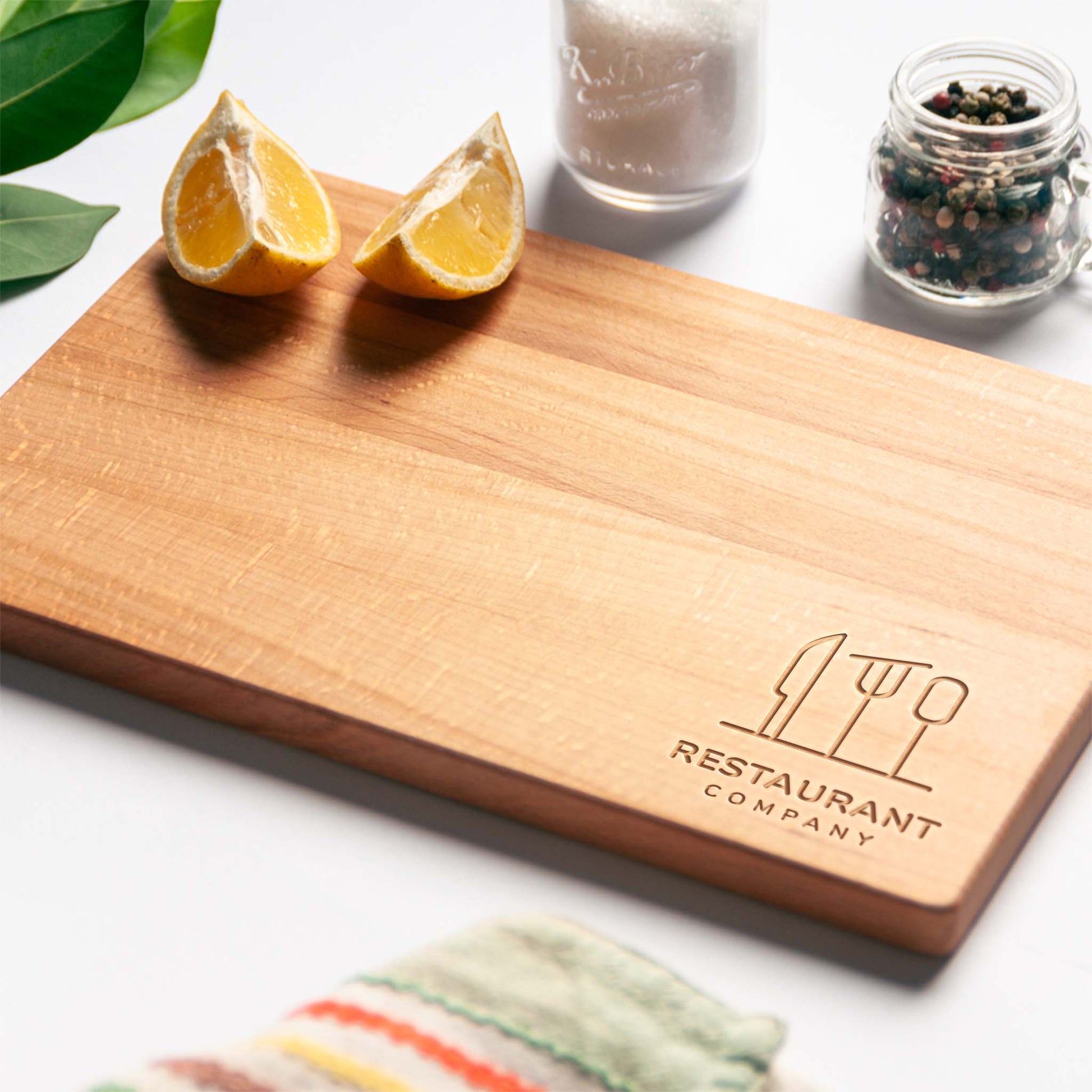 Close-up of laser-engraved logo on beech wood chopping board.