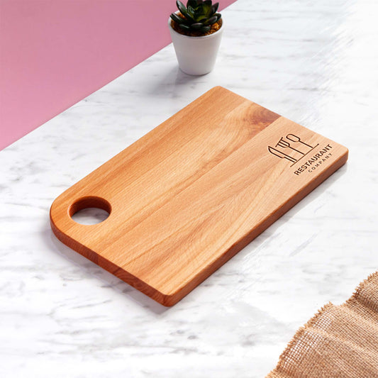 Beech wood cutting board with engraved restaurant logo and hanging hole.