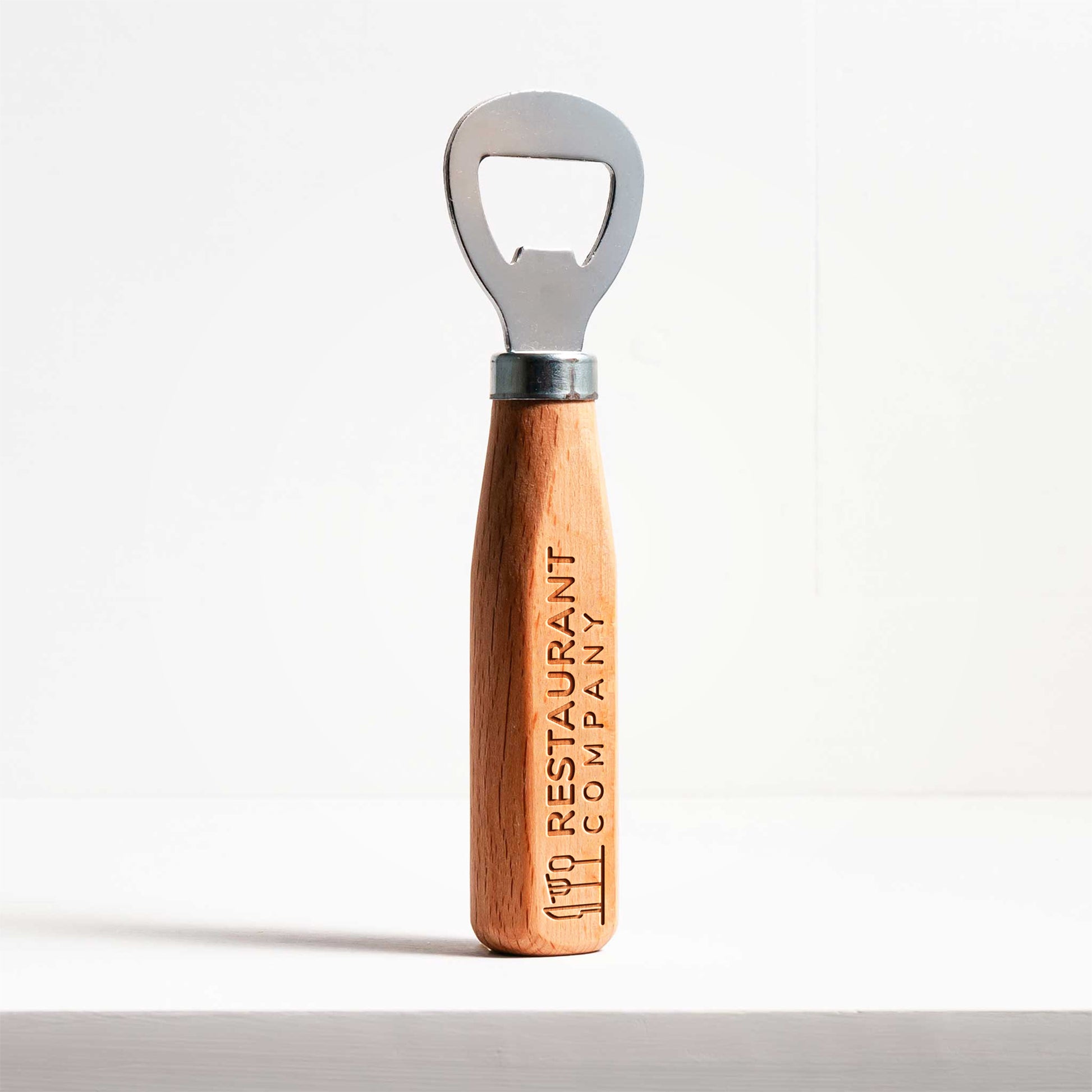 Wooden bottle opener with metal cap on a white background