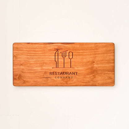 Wooden cutting board with engraved logo and text on a white background