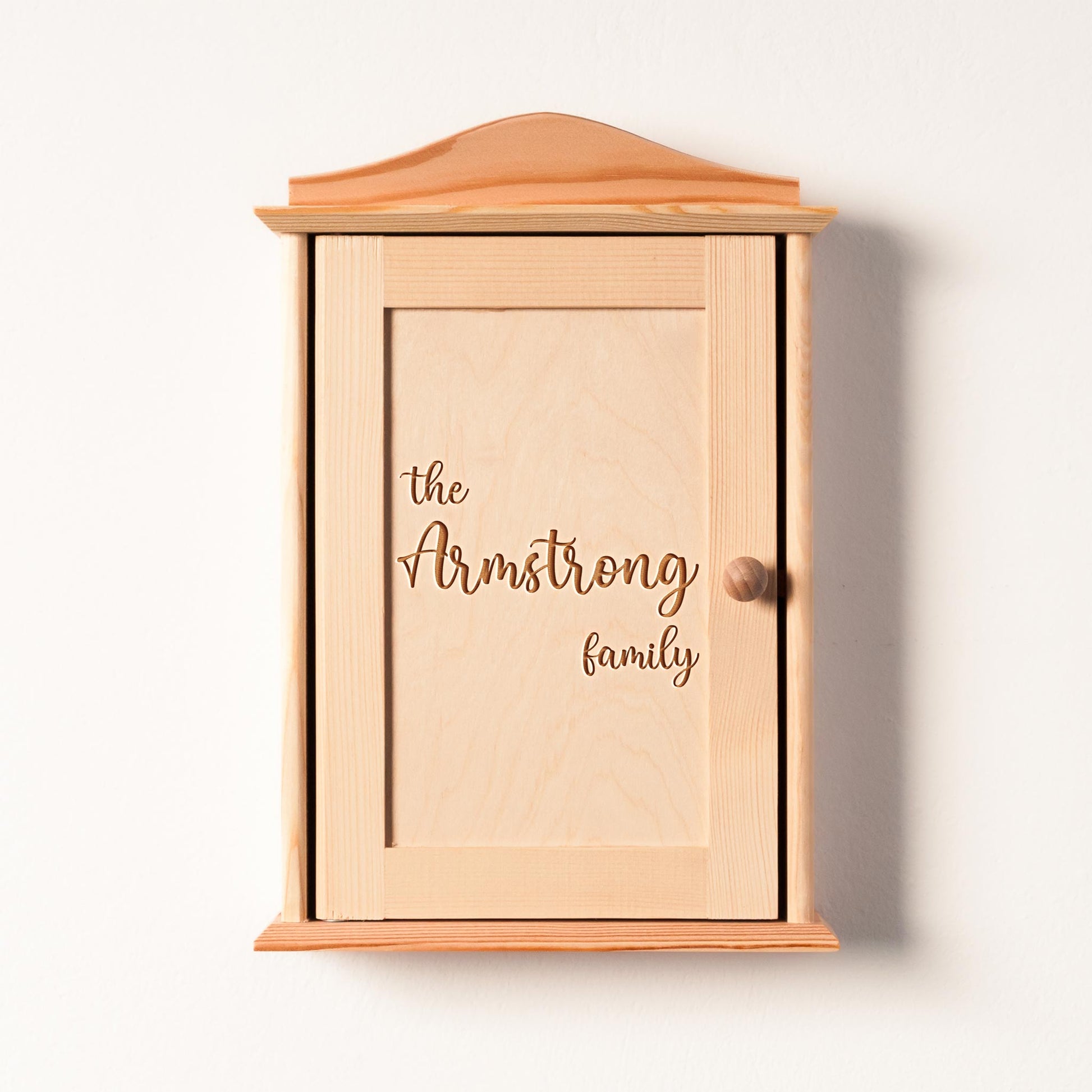 Rustic wooden key holder mounted on entryway wall with keys hanging.