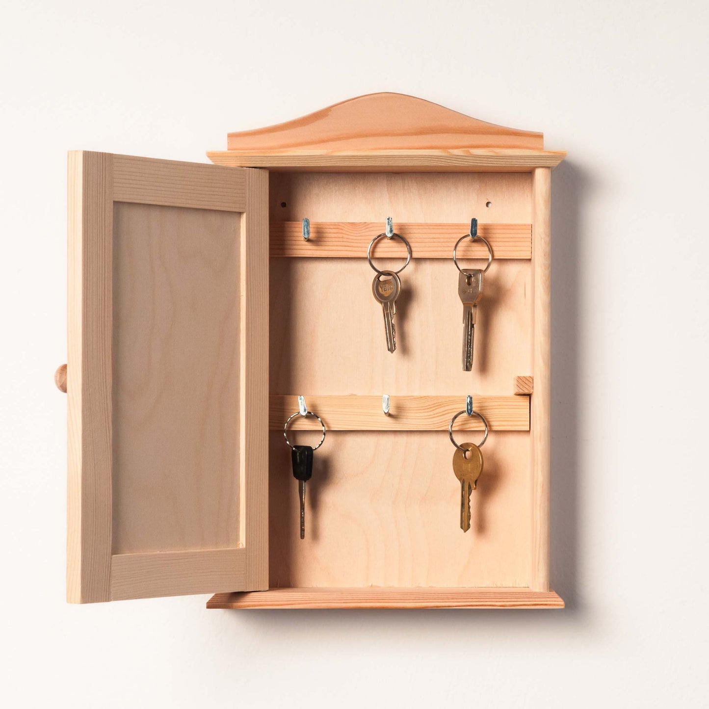 Personalized key holder with engraved family name and decorative hooks.