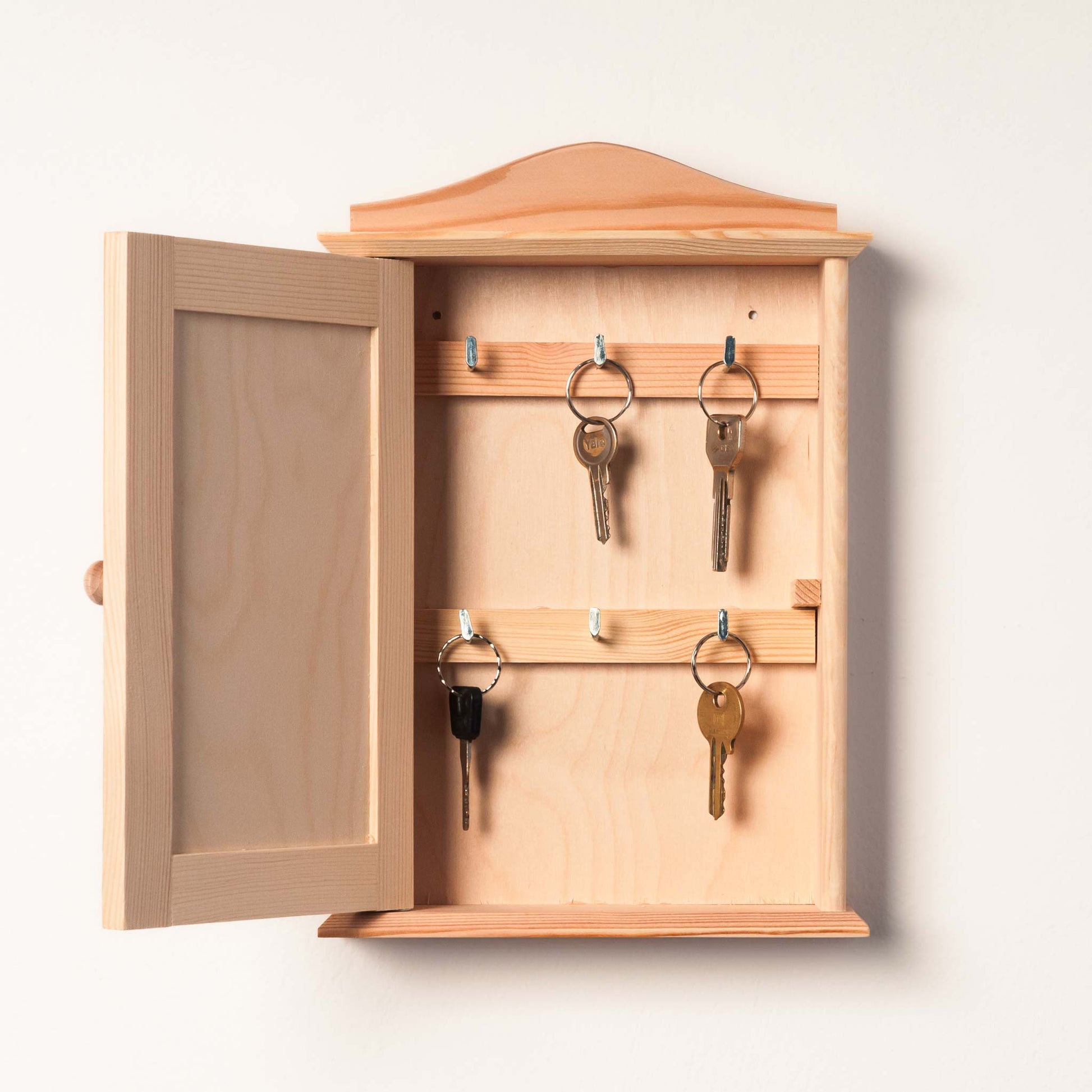 Personalized key holder with engraved family name and decorative hooks.