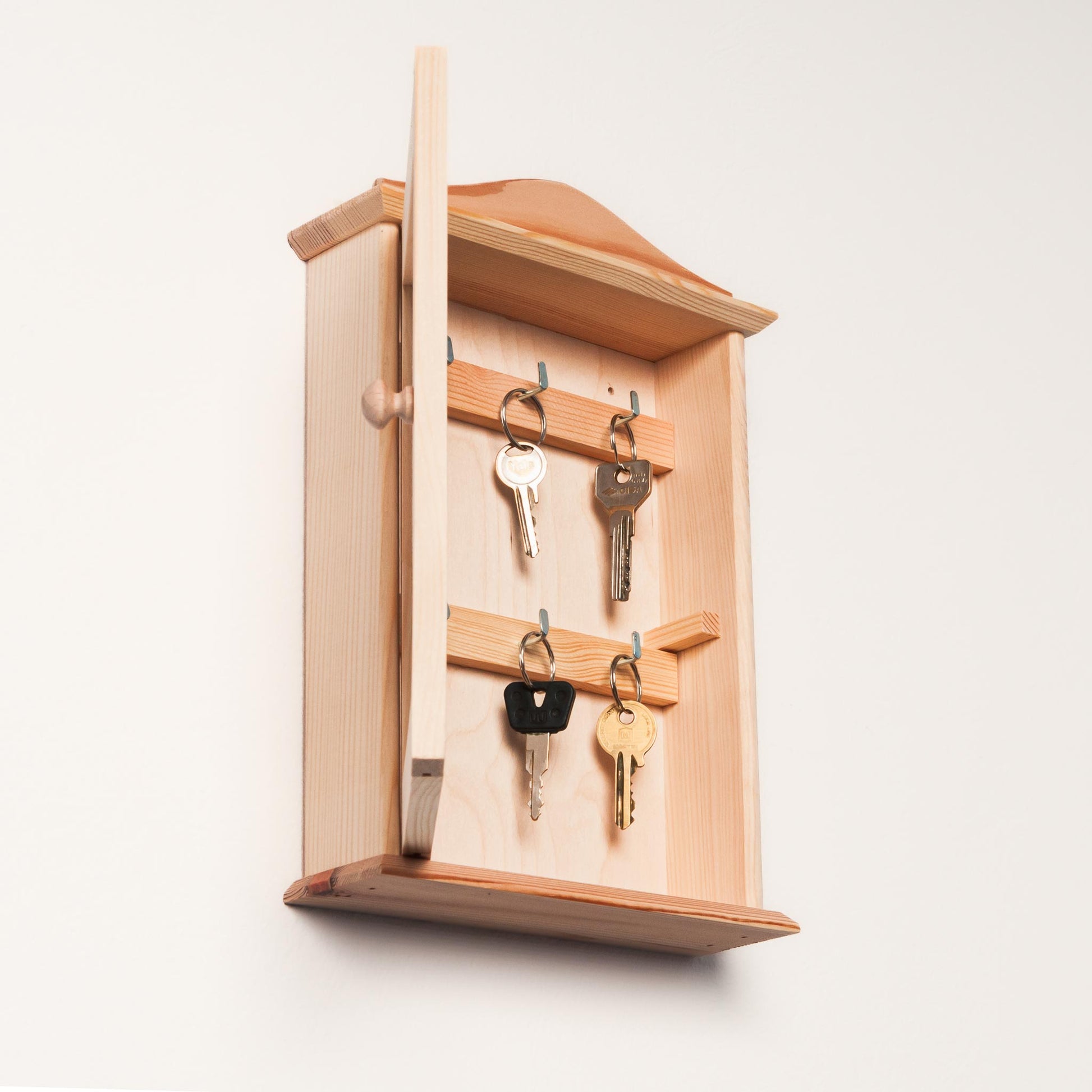 Wall-mounted wooden key holder with custom name engraving, showcasing rustic design.