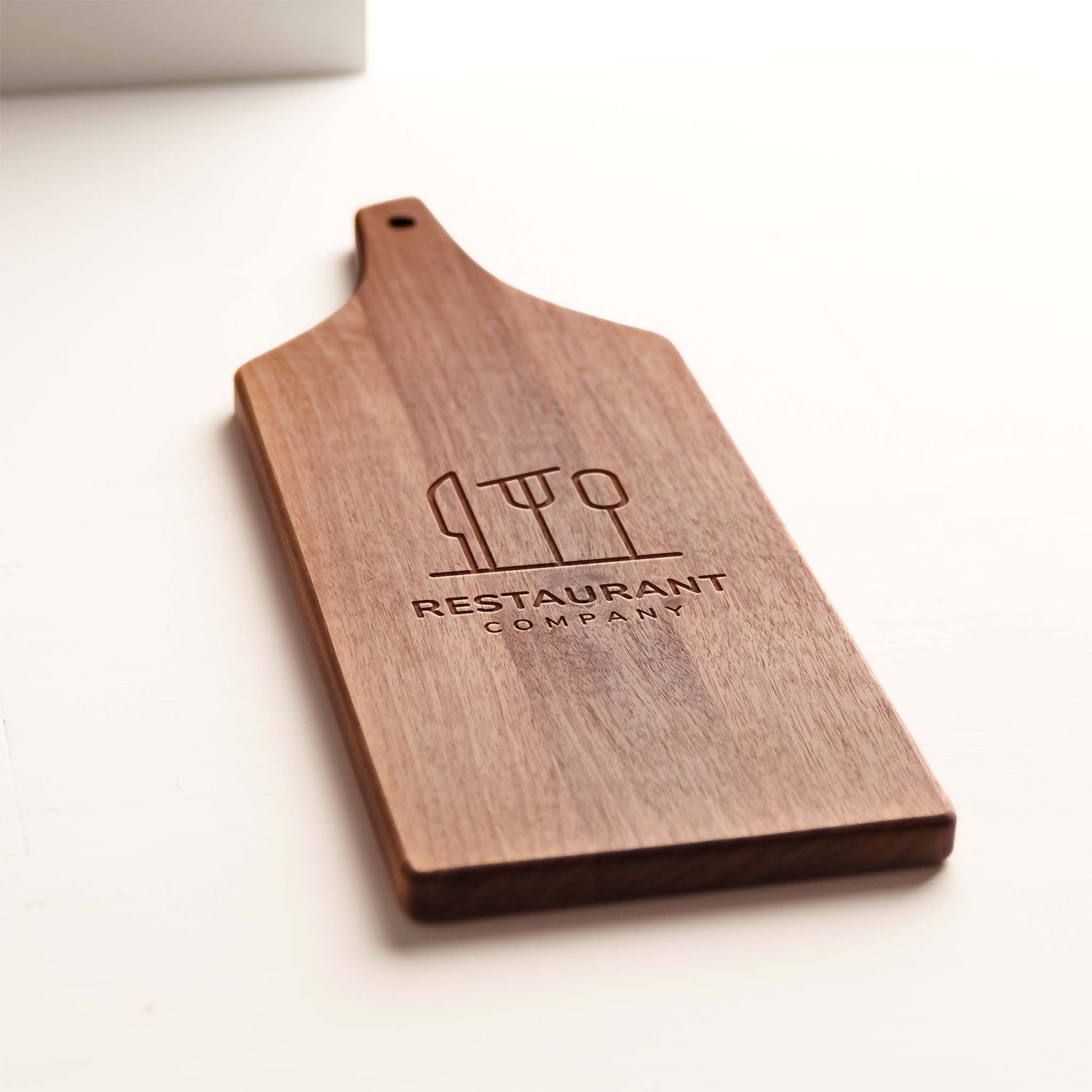 Close-up walnut grain and custom logo engraving on cheese board