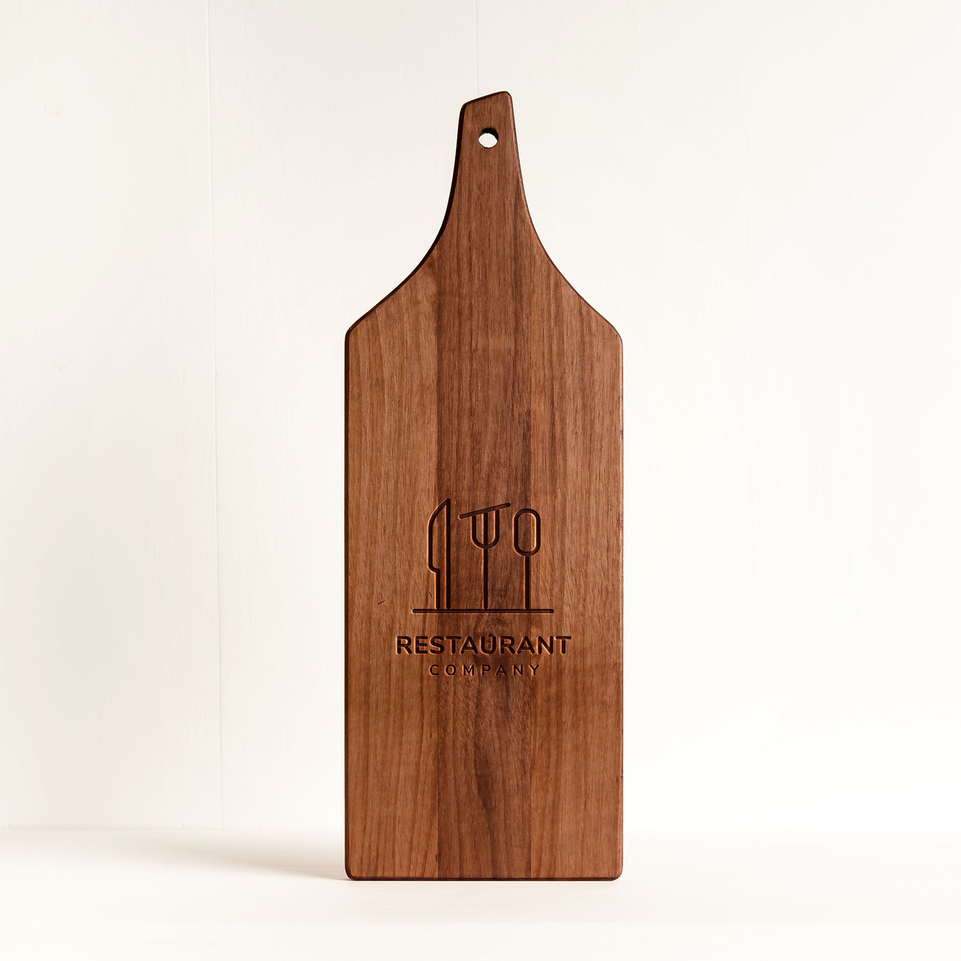Personalized walnut charcuterie board with engraved restaurant logo — top view