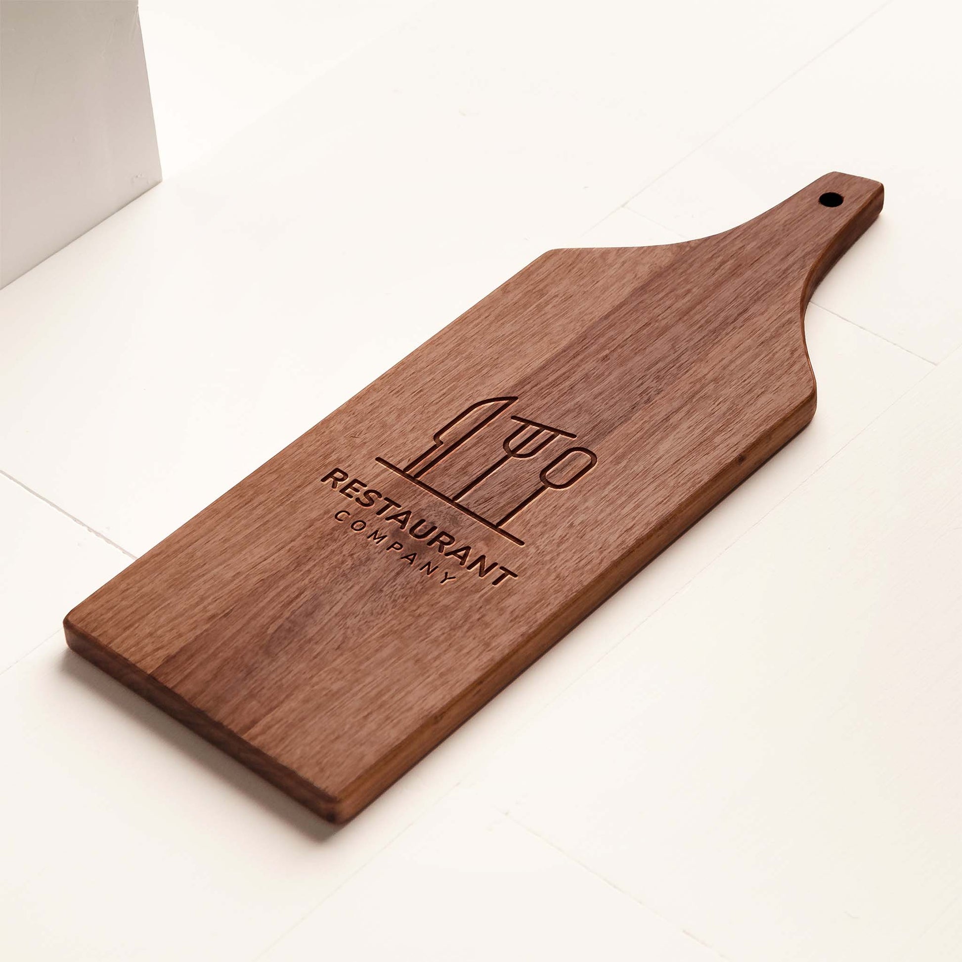 Wooden cutting board with engraved logo on a white background
